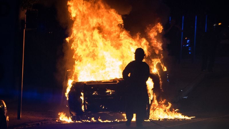 A vehicle burns after a vigil for a Georgia Tech student who was shot dead by campus police turns violent on Sept. 18, 2017.