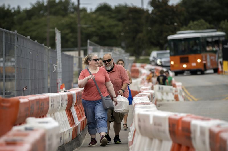 SAVANNAH, GA - JUNE 18, 2024: Parents and seniors of the National Beta Club make their way through construction barriers from the parking lot to the entrance of the Savannah Convention Center, Tuesday, June 18, 2024, in Savannah, Ga. The Beta Club convention is host to more than 22,000 students across grades 4-12. (AJC Photo/Stephen B. Morton)