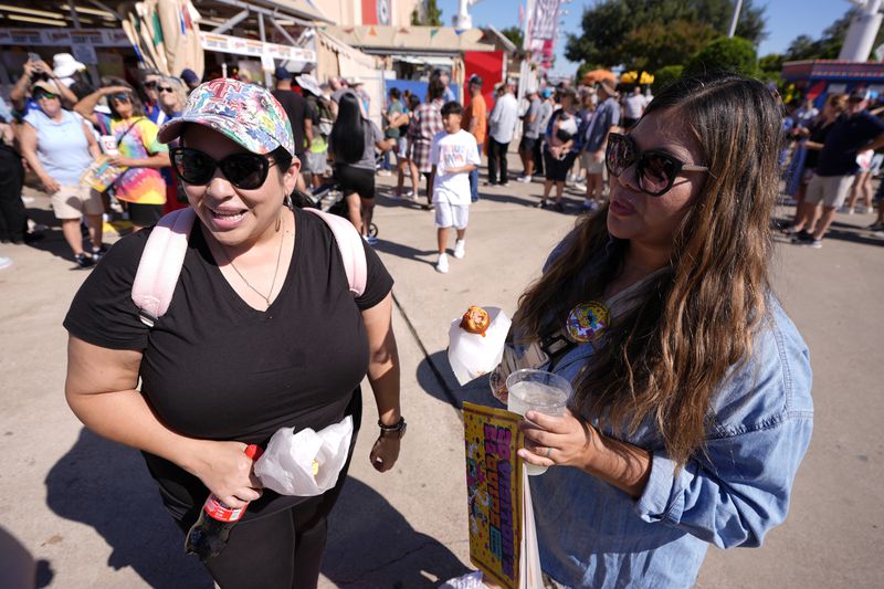 Jamie Rojas, left, and Elvira Torres, right, both of Dallas, respond to a reporter's questions regarding the ban on guns at the State Fair of Texas in Dallas, on Friday, Sept. 27, 2024. (AP Photo/Tony Gutierrez)