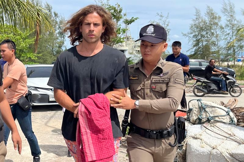 FILE - A Thai police officer escorts Spanish Daniel Sancho Bronchalo on suspicion of murdering and dismembering a Colombian surgeon from Koh Phagnan island to Koh Samui Island court, southern Thailand, Monday, Aug. 7, 2023. (AP Photo/Somkeat Ruksaman, File )