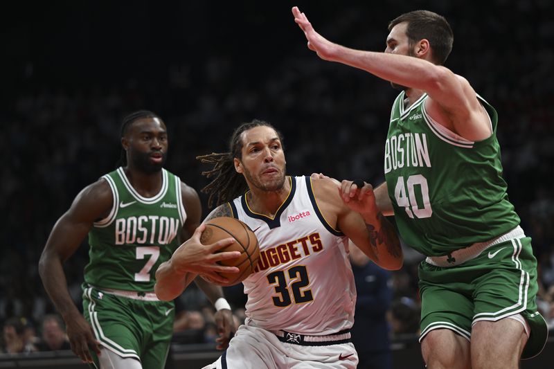 Boston Celtics Luke Kornet guards Denver Nuggets Aaron Gordon during a preseason game between Boston Celtics and Denver Nuggets in Abu Dhabi, United Arab Emirates, Friday, Oct. 4, 2024. (AP Photo/Martin Dokoupil)