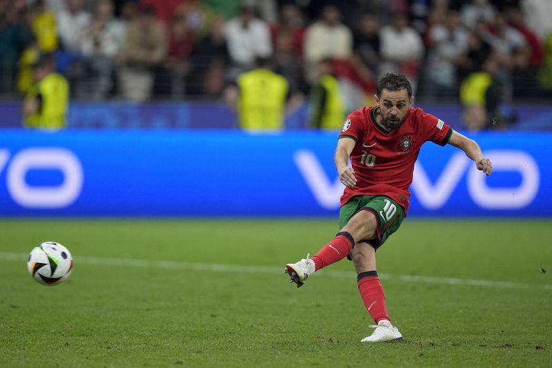 Portugal's Bernardo Silva scores in penalty shoot outs of a round of sixteen match between Portugal and Slovenia at the Euro 2024 soccer tournament in Frankfurt, Germany, Monday, July 1, 2024. (AP Photo/Matthias Schrader)