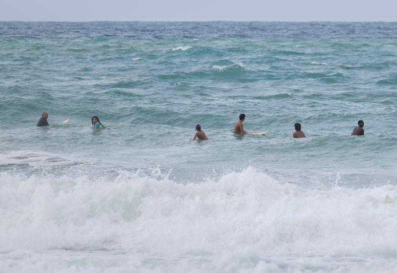 Surfers wait for a wave before the passage of Tropical Storm Ernesto at La Pared beach in Luquillo, Puerto Rico, Tuesday, Aug. 13, 2024. (AP Photo/Alejandro Granadillo)