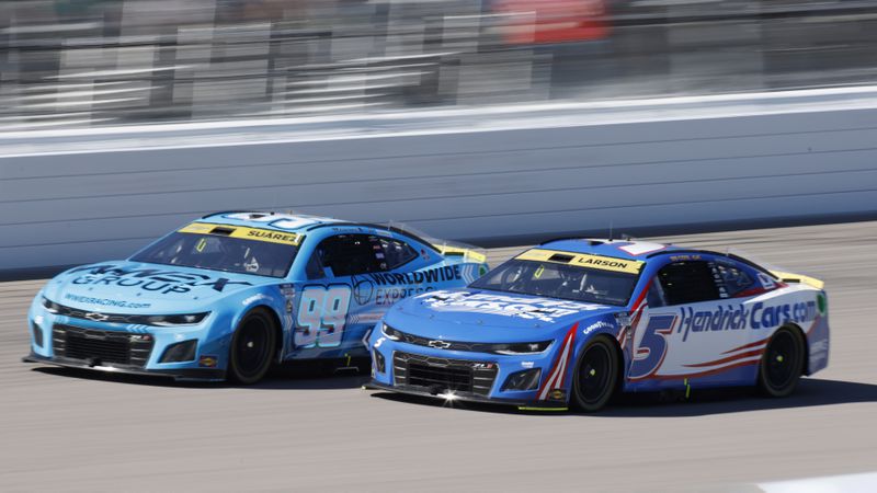 Daniel Suarez (99) and Kyle Larson (5) head down the front straightaway during a NASCAR Cup Series auto race at Kansas Speedway in Kansas City, Kan., Sunday, Sept. 29, 2024. (AP Photo/Colin E. Braley)