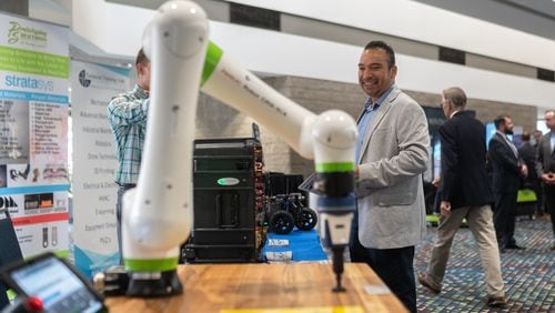 A man looks at a robotic arm being demoed. Georgia Governor Brian Kemp gives the key note address at the Governor's Workforce Summit held at the Georgia World Congress Center. Friday, Sept. 13, 2024 (Ben Hendren for the Atlanta Journal-Constitution)