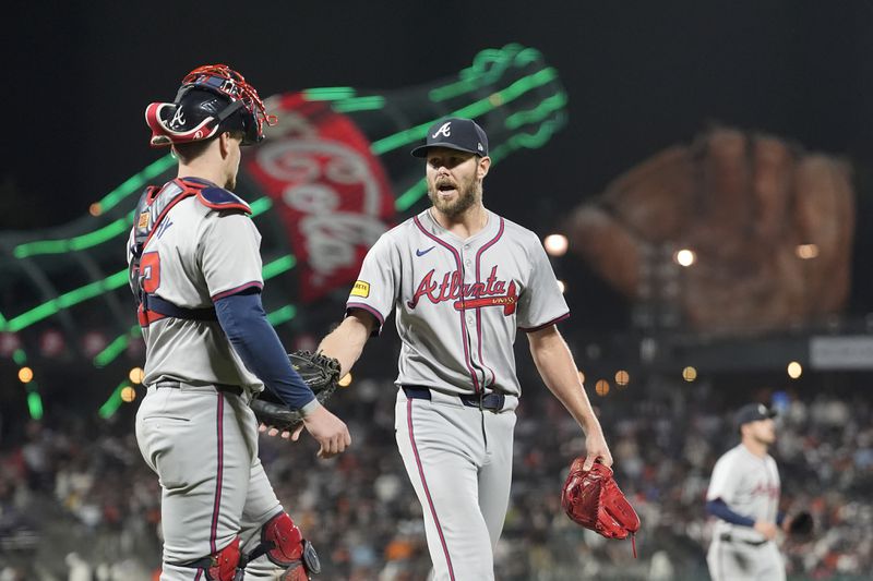 Atlanta Braves catcher Sean Murphy, left, walks off the mound with pitcher Chris Sale after San Francisco Giants' Marco Luciano popped out in foul territory during the seventh inning of a baseball game in San Francisco, Monday, Aug. 12, 2024. (AP Photo/Jeff Chiu)