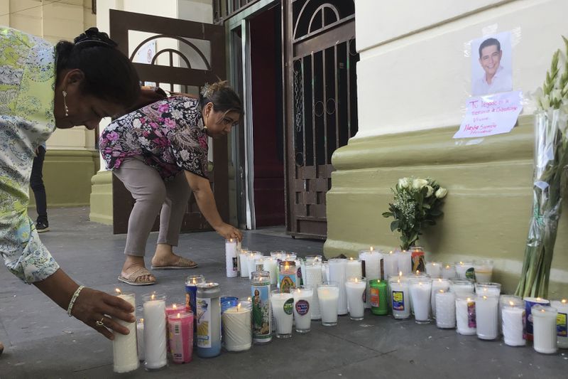 Supporters of slain Mayor Alejandro Arcos place candles and flowers at the entrance of the municipal building one week after he took office in Chilpancingo, Mexico, Monday, Oct. 7, 2024. (AP Photo/Alejandrino Gonzalez)