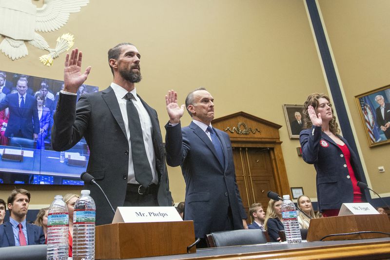 Michael Phelps, former Olympic athlete, left, Travis Tygart, Chief Executive Officer of the U.S. Anti-Doping Agency, center, and Allison Schmitt, former Olympic athlete, are sworn in during a House Committee on Energy and Commerce Subcommittee on Oversight and Investigations hearing examining Anti-Doping Measures in Advance of the 2024 Olympics, on Capitol Hill, Tuesday, June 25, 2024, in Washington. (AP Photo/Rod Lamkey, Jr.)