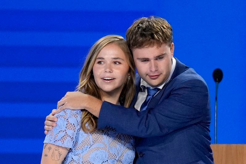 Hope Walz, left, and Gus Walz, children of Democratic vice presidential nominee Minnesota Gov. Tim Walz, right, hug after their father concludes a speech during the Democratic National Convention Wednesday, Aug. 21, 2024, in Chicago. (AP Photo/J. Scott Applewhite)