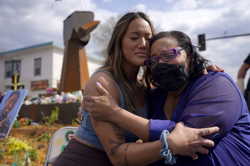 FILE - Community organizer Anthea Yur Kokoro, left, hugs Del Shea Perry, mother of Hardel Sherrell, who died while in police custody, during a rally at the site where George Floyd was killed, in Minneapolis on Sunday, April 18, 2021. (AP Photo/Julio Cortez, File)