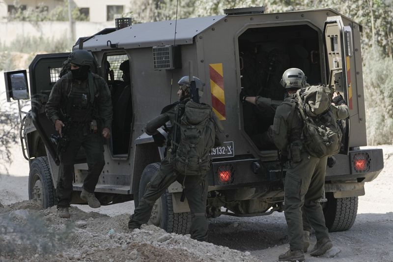 Members of Israeli forces prepare to enter in an armoured vehicle during a military operation in the West Bank refugee camp of Nur Shams, Tulkarem, Thursday, Aug. 29, 2024. (AP Photo/Majdi Mohammed)