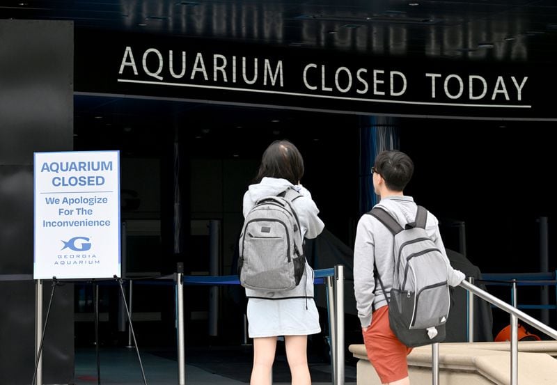 Tourists stand outside Georgia Aquarium after they found out it closed due to water pressure issue, Saturday, June 1, 2024, in Atlanta. A water main that ruptured, causing thousands to lose access to water around Atlanta, was repaired Saturday morning but water may take several hours to be restored. (Hyosub Shin / AJC)