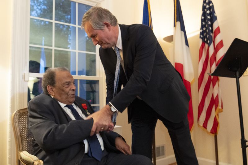 Ambassador Andrew Young shakes hands with French Ambassador to the US Laurent Bili just after receiving the French Legion of Honor medal in Atlanta on Thursday, Oct. 19, 2023.   (Ben Gray / Ben@BenGray.com)