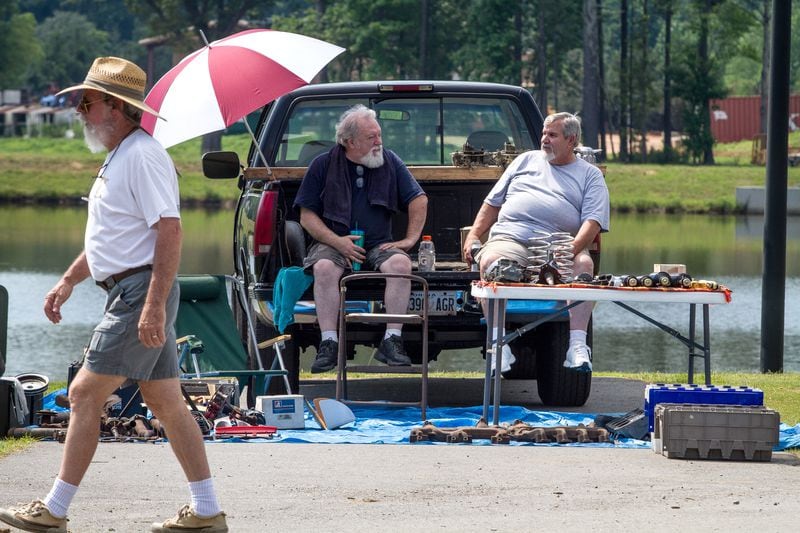 Vic Carroll, left, and John Schneider talk while waiting for customers in the swap meet area of the 28th annual Creepers Car Show at Jim R. Miller Park in Marietta on Saturday.  STEVE SCHAEFER / SPECIAL TO THE AJC