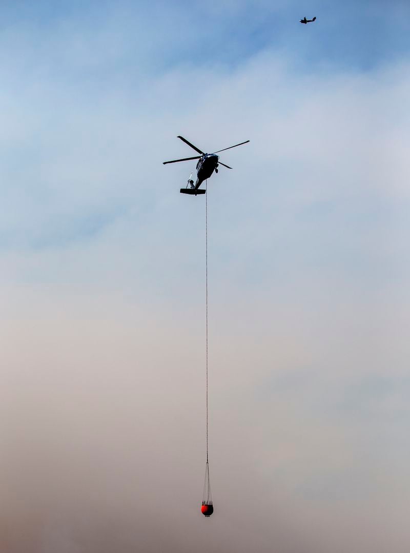 A helicopter flies over a wildfire in Ruidoso, N.M., Tuesday, June 18, 2024. Thousands of residents fled their homes as a wildfire swept into the mountain village of Ruidoso in southern New Mexico. (AP Photo/Andres Leighton)