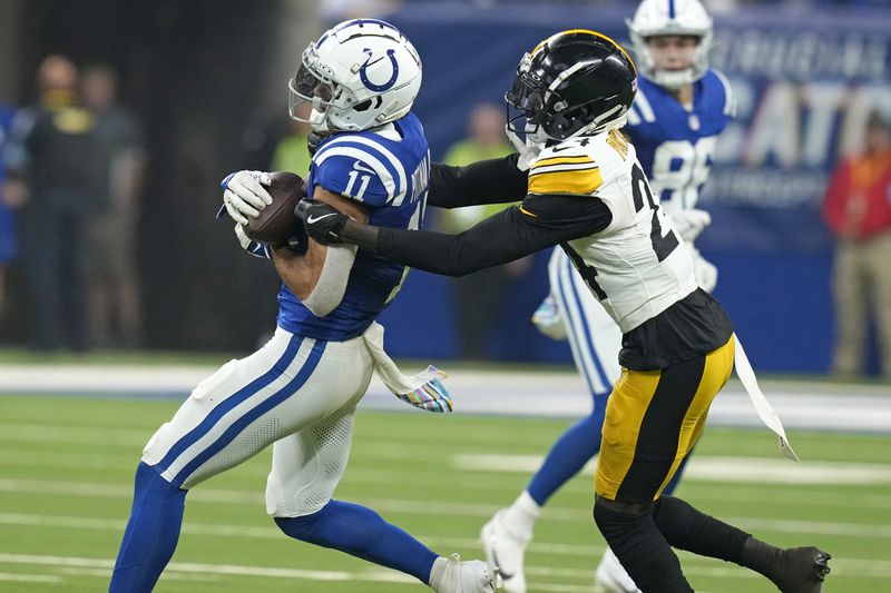 Indianapolis Colts wide receiver Michael Pittman Jr. (11) catches a pass with Pittsburgh Steelers cornerback Joey Porter Jr. (24) defending during the first half of an NFL football game Sunday, Sept. 29, 2024, in Indianapolis. (AP Photo/Darron Cummings)