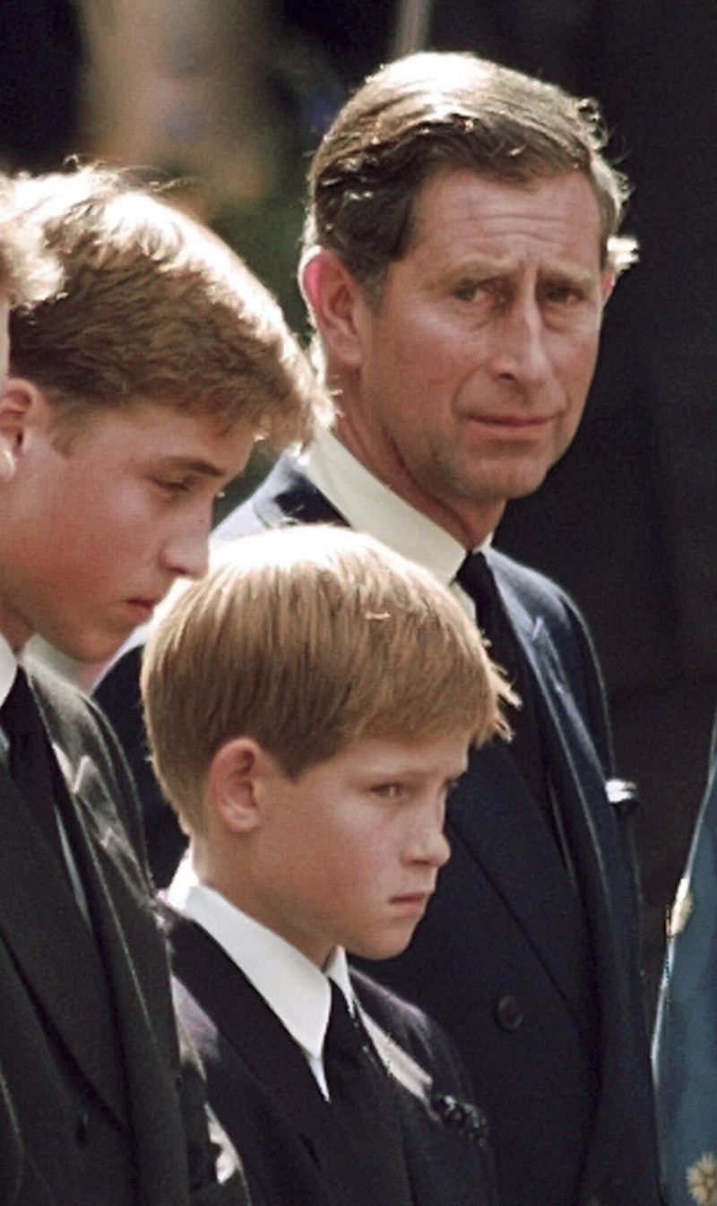 FILE - Britain's Prince Charles, the Prince of Wales, and his sons Prince William, left, and Prince Harry wait for the coffin of Princess Diana to be loaded into a hearse outside of Westminster Abbey, in London on Sept. 6, 1997. (John Gaps III/Pool Photo via AP, File)