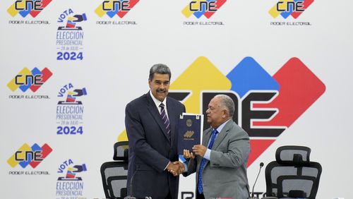 Venezuelan President Nicolas Maduro, left, receives certification from the President of the National Electoral Council (CNE) Elvis Amoroso that he won the presidential election, at the CNE in Caracas, Venezuela, Monday, July 29, 2024. (AP Photo/Matias Delacroix)