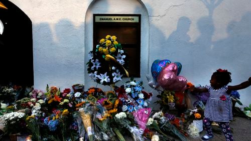 FILE-In this Thursday, June 18, 2015 file photo, mourners pass by a make-shift memorial on the sidewalk in front of the Emanuel AME Church following a shooting by Dylann Roof in Charleston, S.C. A federal jury will consider whether Roof should be sentenced to death or life in prison for killing nine black church members in a racially motivated attack. (AP Photo/Stephen B. Morton, File)