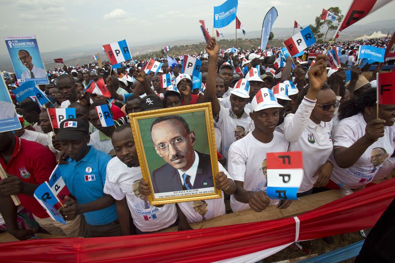 FILE - Supporters of Rwanda's President Paul Kagame, portrait centre, attend an election campaign rally on the hills overlooking Kigali, Rwanda, on April 7, 2019. Rwandans are voting Monday in an election that will almost certainly extend the long rule of Kagame, who is running virtually unopposed after three decades in power in the eastern African nation. (AP Photo/Jerome Delay, File)