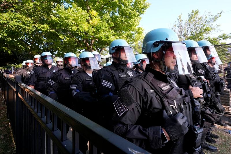 Police line up after a piece of fence was knocked down by protesters surrounding the United Center at the Democratic National Convention Monday, Aug. 19, 2024, in Chicago. (AP Photo/Alex Brandon)