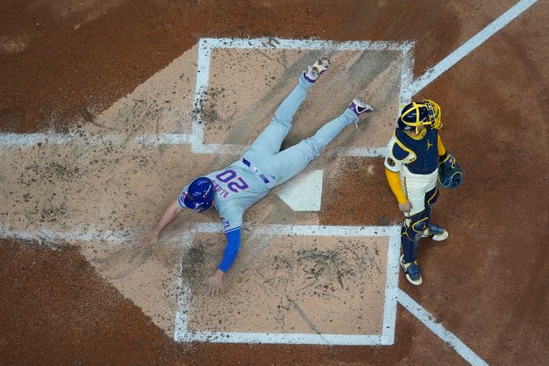 New York Mets' Pete Alonso scores past Milwaukee Brewers catcher William Contreras during the second inning of Game 2 of a National League wild card baseball game Tuesday, Oct. 1, 2024, in Milwaukee. Alonso scored on a triplke by Jesse Winker. (AP Photo/Morry Gash)