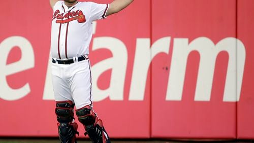 Atlanta Braves catcher Brian McCann stretches in the outfield before the start of a baseball game against the Philadelphia Phillies, Sept. 26, 2013, in Atlanta.