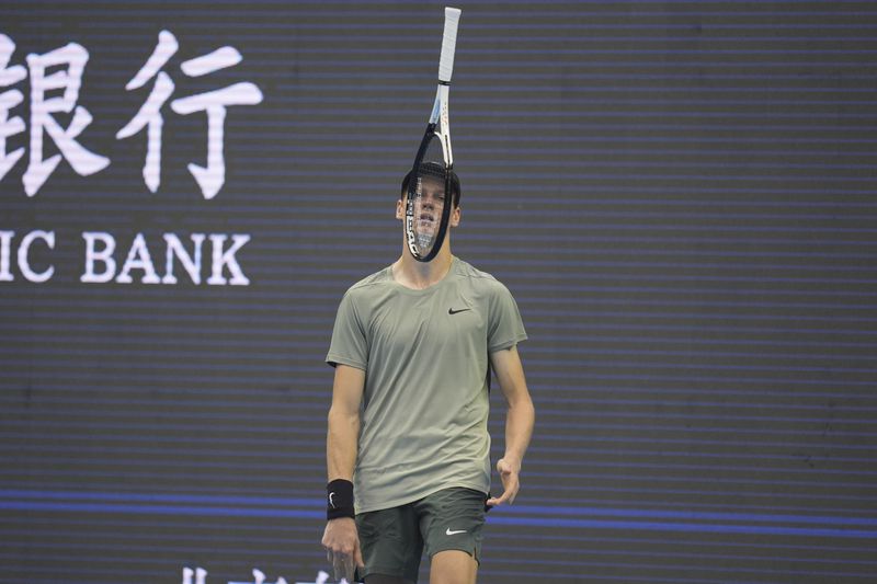 Jannick Sinner of Italy tosses his racket as he waits for play against Roman Safiullin of Russia during the China Open tennis tournament held at the National Tennis Center in Beijing, Saturday, Sept. 28, 2024. (AP Photo/Ng Han Guan)