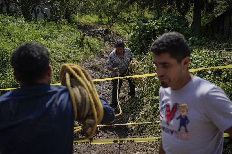 Residents volunteer at the site where various people died after a rain-induced landslide, in Naucalpan, Mexico, Tuesday, Sept. 17, 2024. (AP Photo/Felix Marquez)