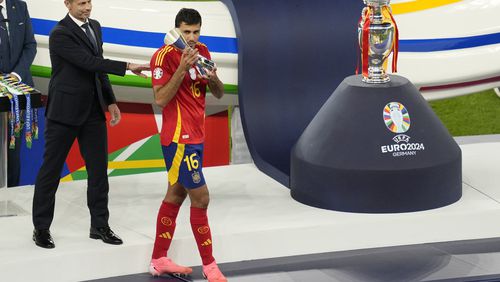 FILE - Spain's Rodri holds the player of the tournament trophy after the final match between Spain and England at the Euro 2024 soccer tournament in Berlin, Germany, July 14, 2024. Jude Bellingham and Rodri have key starring roles for title-winning soccer clubs and their national teams. Neither is currently playing matches. (AP Photo/Andreea Alexandru, File)