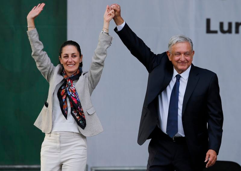 FILE - Then Mexico City Mayor Claudia Sheinbaum and Mexican President Andres Manuel Lopez Obrador greet supporters at a rally marking the one-year anniversary of his election, in the Zocalo of Mexico City, July 1, 2019. Sheinbaum will be sworn in as Mexico’s first woman president on Oct. 1. (AP Photo/Fernando Llano, File)