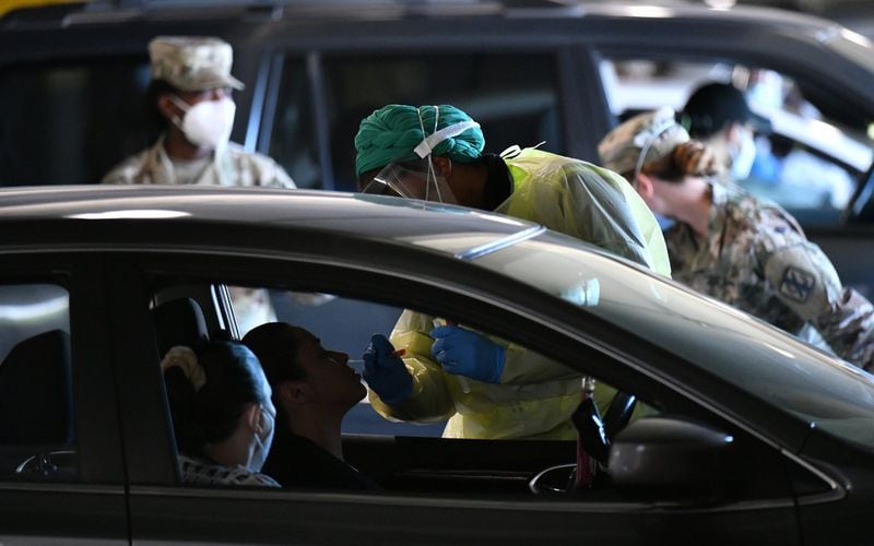 A medical professional collects a nasal swab at a drive-thru COVID-19 testing site for anyone experiencing symptoms at the Infinite Energy Center in Duluth on Wednesday, April 22, 2020. The Gwinnett, Newton and Rockdale County Health Department conducted 800 tests at the venue, its second large-scale testing event in a week. (Hyosub Shin / Hyosub.Shin@ajc.com)