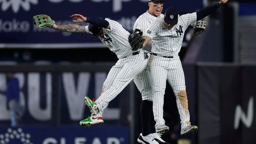 New York Yankees left fielder Alex Verdugo, left, center fielder Aaron Judge, center, and Juan Soto celebrate after beating the Kansas City Royals in Game 1 of the American League baseball division series, Saturday, Oct. 5, 2024, in New York. (AP Photo/Adam Hunger)