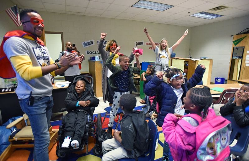 Standing, from left, Robert Stewart (assistant principal), Thalise Perry (principal) and Ashlee Simmons (special education teacher) congratulate students after Perry announced the class was chosen to participate in the attendance run, a weekly reward for perfect attendance, at Miles Elementary School on Friday, Nov. 22, 2019.HYOSUB SHIN / HYOSUB.SHIN@AJC.COM
