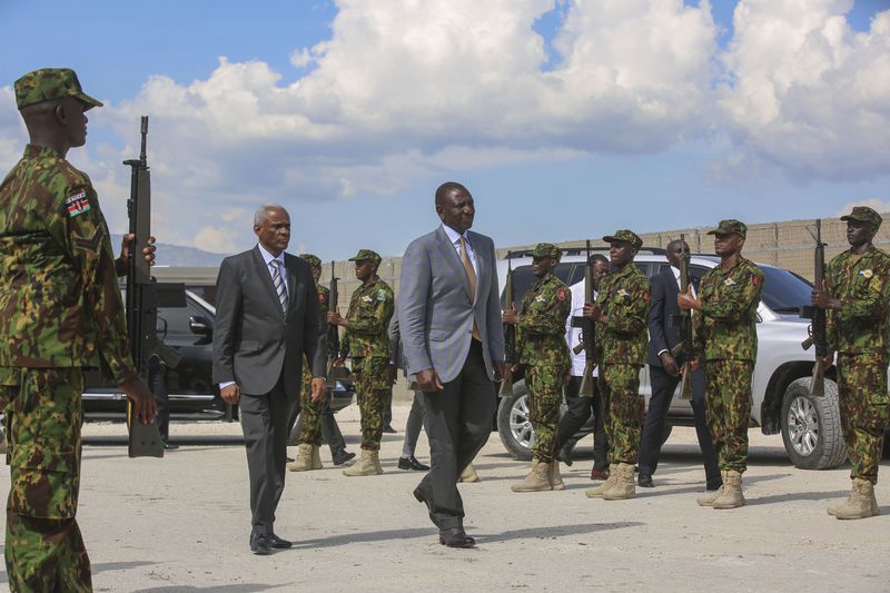 Kenya's President William Ruto, center right, walks with Transition Council President Edgard Leblanc, as they arrive to the Kenyan base in Port-au-Prince, Haiti, Saturday, Sept. 21, 2024. (AP Photo/Odelyn Joseph)