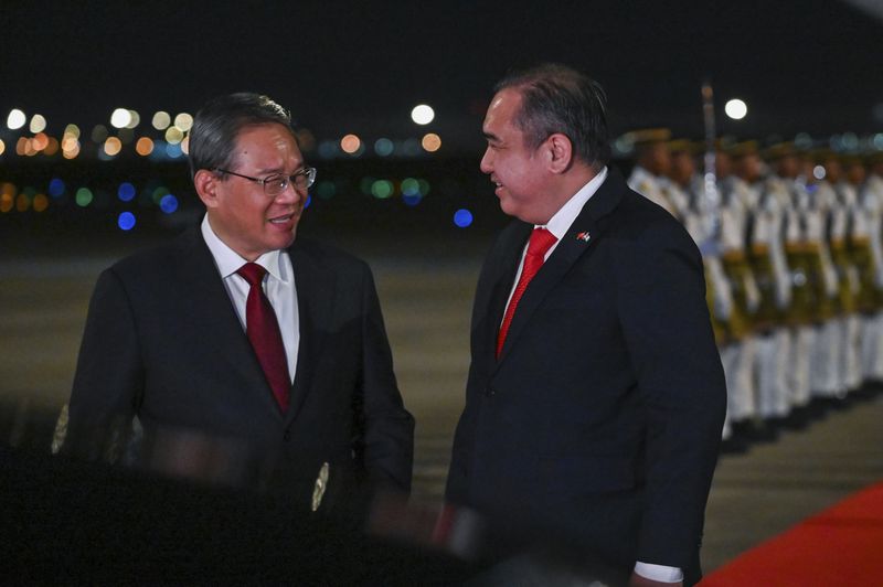 In this photo released by Malaysia's Department of Information, China's Premier Li Qiang, left, is greeted by Malaysia's Minster of Transport, Anthony Loke, as he arrives at Sepang International Airport in Kuala Lumpur, Malaysia, Tuesday, June 18, 2024. (Malaysia's Department of Information via AP)
