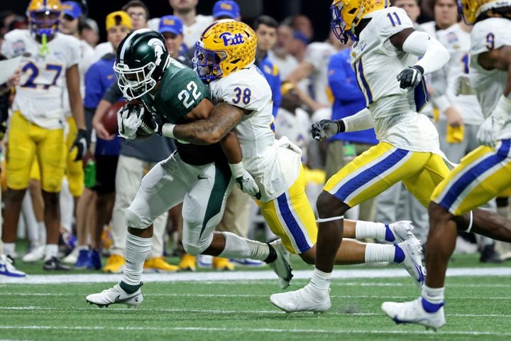 Michigan State Spartans running back Jordon Simmons (22) runs against Pittsburgh Panthers linebacker Cam Bright (38) during the first half of the Chick-fil-A Peach Bowl at Mercedes-Benz Stadium in Atlanta, Thursday, December 30, 2021. Simmons is a graduate of McEachern high school. JASON GETZ FOR THE ATLANTA JOURNAL-CONSTITUTION