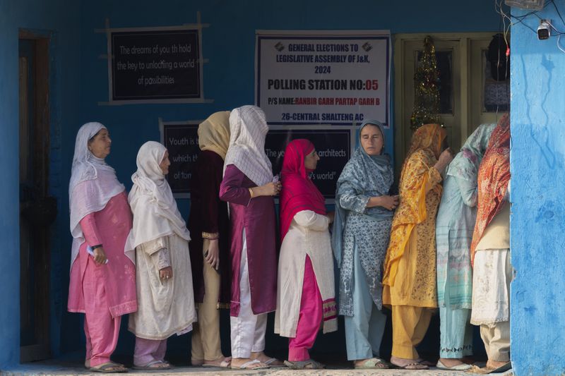 Kashmiri women queue up at a polling booth to cast their vote during the second phase of the assembly election in the outskirts of Srinagar, Indian controlled Kashmir, Wednesday, Sept. 25, 2024. (AP Photo/Dar Yasin)