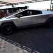 FILE - Visitors look over a 2024 Cybertruck in the Tesla display at the Electrify Expo, July 14, 2024, in north Denver. (AP Photo/David Zalubowski, File)