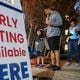 Josh Weeks waits in line with son, Noah-4 as early voters hit the polls Friday, Nov. 4, 2022 at the Joan P. Garner Library in Atlanta.  (John Spink / John.Spink@ajc.com)