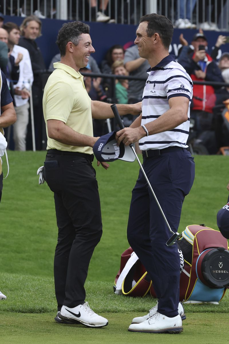 Billy Horschel of the United States, right shakes hands with Rory McIlroy, of Northern Ireland, on the 18th green with Horschel winning a playoff to win the British PGA golf Championship at Wentworth golf club in Wentworth, England, Sunday, Sept. 22, 2024. (AP Photo/Ian Walton)