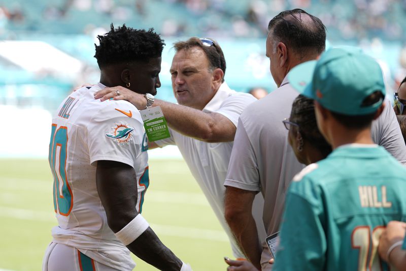 Miami Dolphins wide receiver Tyreek Hill (10) listens to agent Drew Rosenhous before NFL football game against the Jacksonville Jaguars, Sunday, Sept. 8, 2024, in Miami Gardens, Fla. (AP Photo/Rebecca Blackwell)