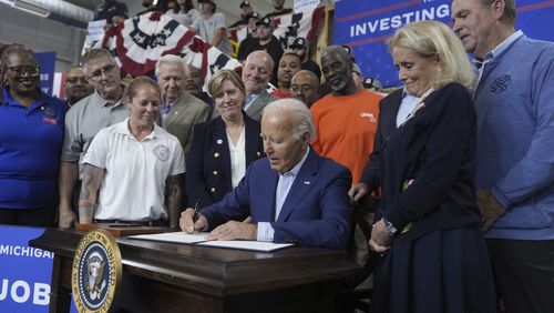 President Joe Biden participates in a signing ceremony after speaking to labor union members about his Investing in America agenda during a visit to the U.A. Local 190 Training Center in Ann Arbor, Mich., Friday, Sep. 6, 2024, as Rep. Debbie Dingell, D-Mich., right, looks on. (AP Photo/Manuel Balce Ceneta)