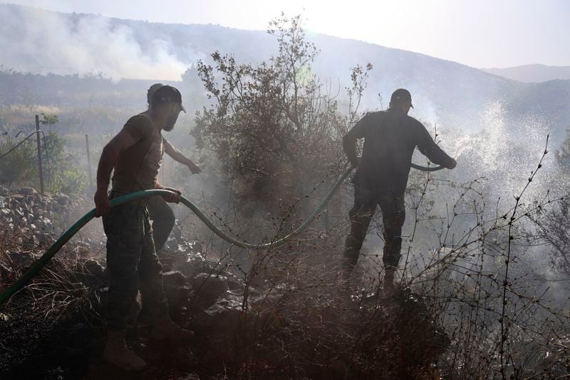 Lebanese Civil Defence firefighters extinguish fires that erupted by Israeli shelling at a cherry orchard in Chebaa, a Lebanese town near the border with Israel, south Lebanon, Friday, June 14, 2024. AP Photo/Ramiz Dallah)