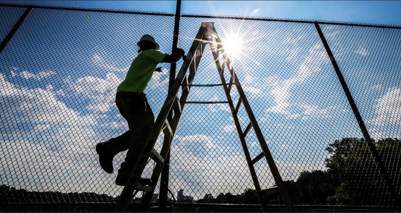 Alexander Gutierrez with Paul Wiley Electrical works on the new tennis courts on Tuesday, August 28, 2018  will be opening at the Bitsy Grant Tennis Center in Atlanta.