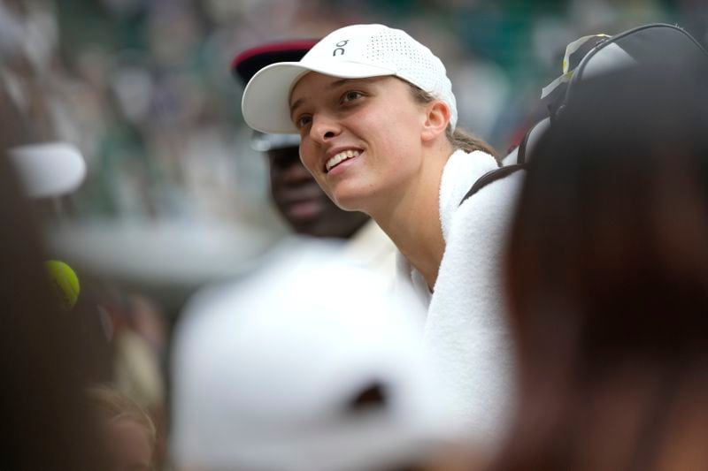 Iga Swiatek of Poland poses for a photo after defeating Sofia Kenin of the United States in their first round match at the Wimbledon tennis championships in London, Tuesday, July 2, 2024. (AP Photo/Mosa'ab Elshamy)