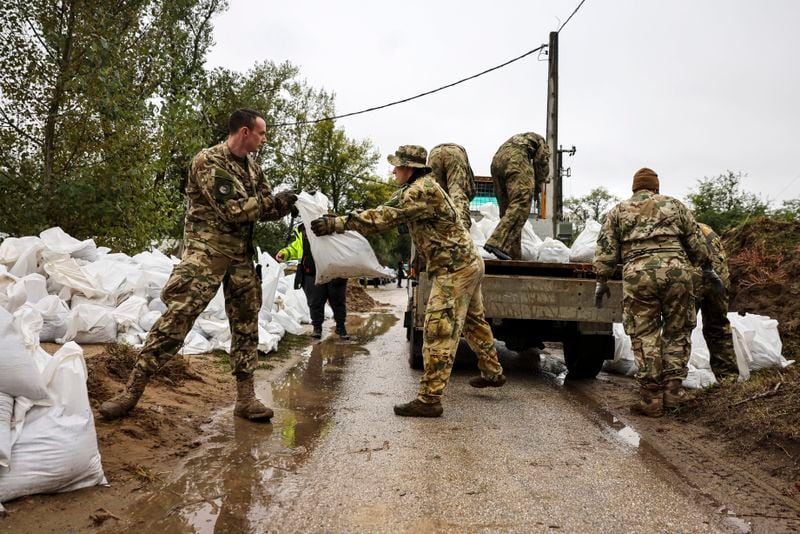 Soldiers build barriers with sandbags against flood water at the bank of Danube River in Pilismarot, Hungary, Monday, Sept. 16, 2024. (Robert Hegedus/MTI via AP)