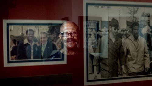Former POW Lt. Col. James W. Williams, in Norcross this month, is reflected in a framed photo of himself with President Richard Nixon, left, and a photo of him being escorted as a prisoner of war. Willams was shot down while flying a F-4D Phantom during a mission over North Vietnam. BRANDEN CAMP/SPECIAL