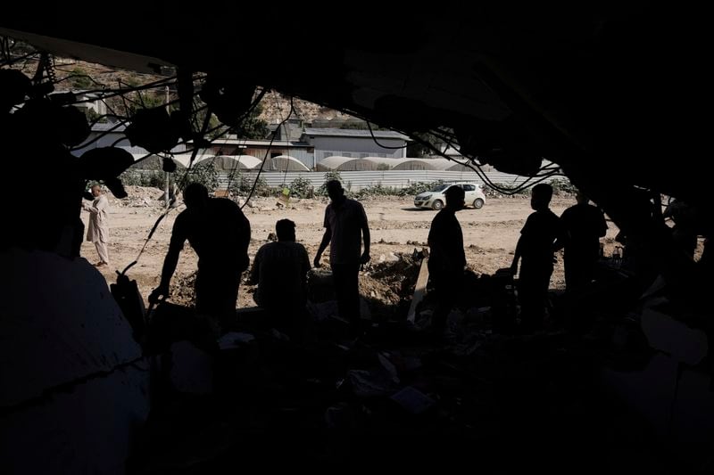 People inspect the destruction following an Israeli forces raid in Tulkarem, West Bank, on Wednesday, Sept. 11, 2024. (AP Photo/Majdi Mohammed)