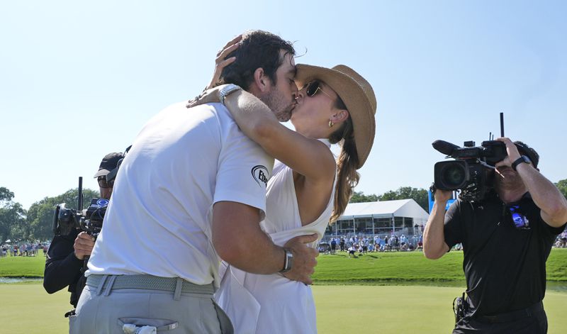 Davis Riley, left, gets a kiss from his wife Alexandra Patton Riley after he won the Charles Schwab Challenge golf tournament at Colonial Country Club in Fort Worth, Texas, Sunday, May 26, 2024. (AP Photo/LM Otero